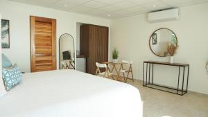 林康Tres Palmas by La Cambija的卧室配有一张白色的大床和一张桌子