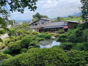 Matsukawa離れの宿　かぶろの庭的花园中带池塘的房子
