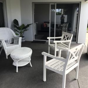 新普利茅斯Beachside studio的一组白色的椅子和一张桌子及一把椅子