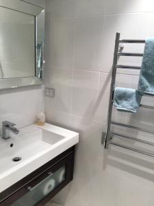 新普利茅斯Beachside studio的浴室配有盥洗盆、镜子和毛巾架