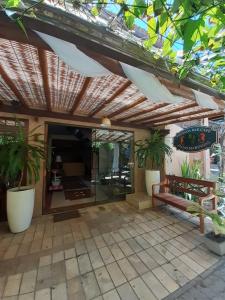 普拉亚多Pousada Bar Café Algas Marinhas的一个带木制凉棚和一些植物的庭院