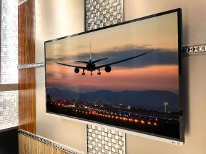 东京Hotel Amethyst的挂在墙上的电视,上面有飞机的照片