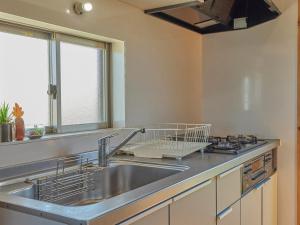 宜野座斯纳敦度假屋的厨房配有水槽和炉灶