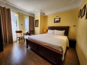 河内经典街酒店的一间卧室配有一张大床和一把椅子