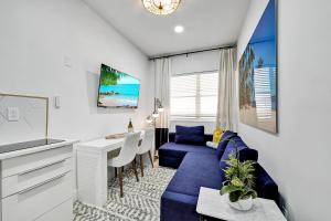 迈阿密海滩SOBE MONARCH 2BEDROOM 2 BATH MODERN apt- WALK TO OCEAN DRIVE的客厅配有蓝色的沙发和桌子