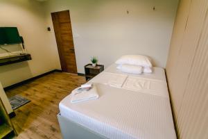 杜马格特Midway Stay Apartments Dumaguete的小房间设有一张床和一台平面电视