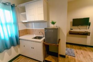 杜马格特Midway Stay Apartments Dumaguete的一间带水槽的小厨房和一台电视