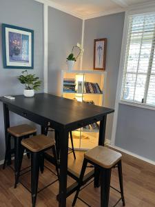 肯图巴Blissful Mountain Stay的一张黑色餐桌,在房间里摆放着两张凳子