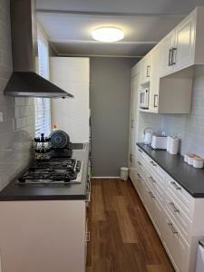 肯图巴Blissful Mountain Stay的厨房配有白色橱柜和炉灶烤箱。