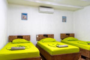 塔马林多Hotel El Baquiano的配有两张床铺的客房配有黄色床单和枕头