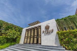 奈扬海滩Proud Phuket Hotel, Naiyang Beach的一座带楼梯的建筑前方的纪念碑