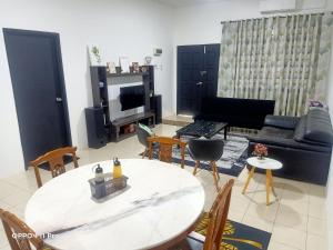 关丹Homestay Izzauni的客厅配有桌椅和沙发