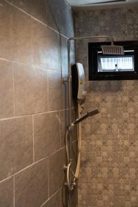 合艾合艾我们世界精品酒店的带淋浴的浴室(带瓷砖墙)