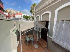 圣克鲁斯-德特内里费Casa Almendra的阳台的天井配有桌子和遮阳伞。