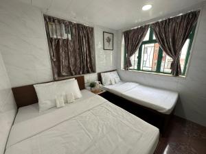 香港Mandarin Guest House的小房间设有两张床和窗户