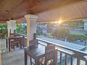 琅勃拉邦Villa KhounSok Sunset的门廊上设有带桌椅的天井。