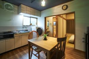 东京Kagurazaka Retro BAR & HOTEL的一间带木桌的厨房和一间餐厅