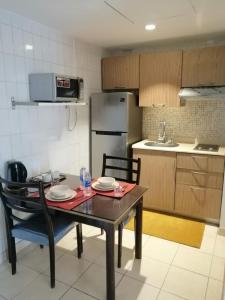 科威特科威特公寓的厨房配有桌子、两把椅子和冰箱