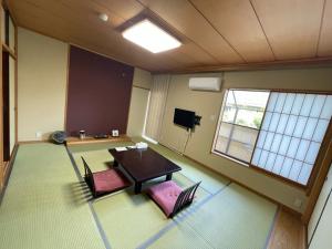 Isawa貸切温泉風呂付 ゲストハウス璃洛-りらく- 石和温泉 日本式宿 健康朝食付的一间空房间,配有桌子和两把椅子