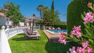 隆达Casa Rural Marquez Ronda by Ruralidays的后院设有游泳池、椅子和鲜花