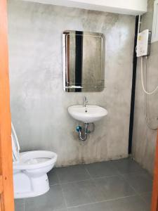 乌泰他尼府SolarCell Private Homestay - โซล่าเซลล์ไพรเวทโฮมสเตย์的一间带卫生间、水槽和镜子的浴室