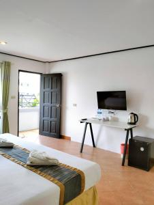 普吉镇Blue Carina Hotel - SHA Plus的客房设有两张床、一张桌子和一台电视。