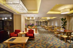 杭州杭州武林万怡酒店的用餐室配有桌子和红色椅子以及桌上桌