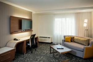 瓦拉瓦拉沃拉沃拉万怡酒店的酒店客房配有一张床、一张书桌和一张沙发。