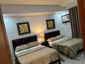 马尼拉My Suite Heart of San Juan City Philippines的一间酒店客房,房间内设有两张床