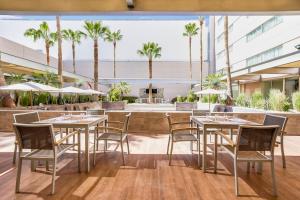 托雷翁托雷翁加莱里亚斯圣日酒店的一间设有桌椅的餐厅,种植了棕榈树