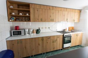 布什泰尼Casa Liana的厨房配有木制橱柜、炉灶和微波炉。