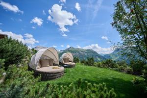 莱赫阿尔贝格莫嫩弗鲁酒店的两顶帐篷位于山丘上,山丘背景