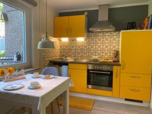 吕格德Ferienwohnung Amselnest的厨房配有黄色橱柜和白色桌子
