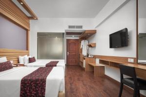 金边欧汉娜金边皇宫酒店的酒店客房设有两张床和一台平面电视。