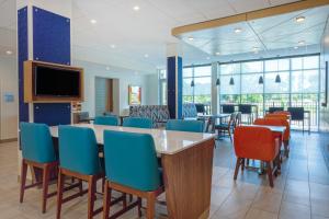 斯塔克Holiday Inn Express - Starke, an IHG Hotel的一间设有桌椅和电视的等候室