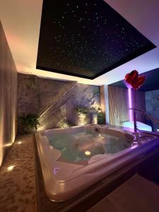 BonnevalLes Secrets Rooms - Bonneval - Love Room - Spa et Hammam Privatif的设有带大浴缸的浴室,浴室拥有星星天花板
