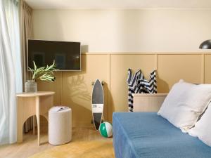 斯海弗宁恩卡尔顿海滩的卧室配有一张床,墙上设有冲浪板