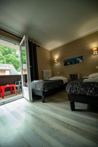 圣热尔韦莱班Hotel La Chaumiere的一间卧室设有两张床和滑动玻璃门