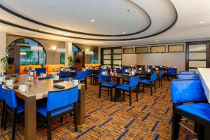 圣地亚哥圣地亚哥机场/自由站万怡酒店的一间配备有桌子和蓝色椅子的用餐室