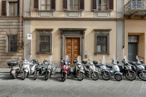 佛罗伦萨Mamo Florence - Aperol & Spritz Apartments的停在大楼前的一排摩托车