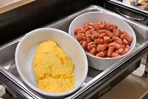 和歌山和歌山城市酒店的托盘,盘子上放着两碗食物,煎蛋和胡萝卜