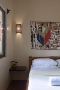 长滩岛懒汉食宿酒店的一间卧室设有两张床,墙上挂着一幅画
