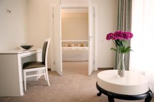 纳尔瓦约埃苏Noorus SPA Hotel的一间设有一张桌子和紫色花瓶的房间