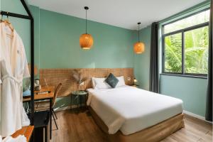 富国Leaf Hotel Phu Quoc的一间卧室配有一张床、一张书桌和一个窗户。