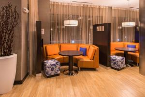 杰克逊维尔杰克逊维尔万豪万怡酒店的一间配备有橙色椅子和桌椅的等候室