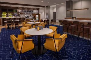 圣安吉洛圣安吉洛万怡酒店的一间设有黄色桌椅的餐厅和一间酒吧