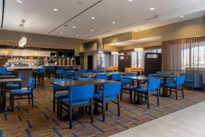 Arden阿什维尔机场万怡酒店的一间配备有蓝色椅子和桌子的用餐室