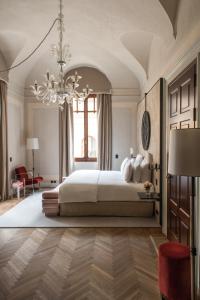威尼斯Nolinski Venezia - Evok Collection的一间卧室配有一张大床和一个吊灯。
