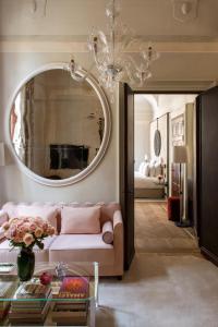 威尼斯Nolinski Venezia - Evok Collection的客厅配有粉红色的沙发和镜子