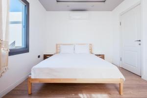 博德鲁姆Chic Flat w Balcony 3 min to Beach in Bodrum的卧室配有一张带白色床单的大床和窗户。